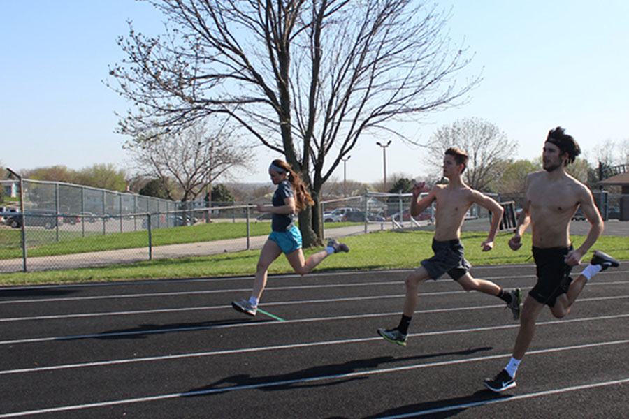 Seniors Bryson Williams, Chase Scott and junior Kortney Buresh train for long distance running during practice.