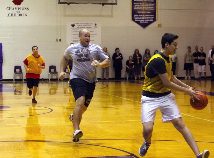 Mr. Rosa steals the ball from Mr. Moore at the staff basketball game for FBLAs March of the Dimes fundraiser. Photo by Tessa Perez.