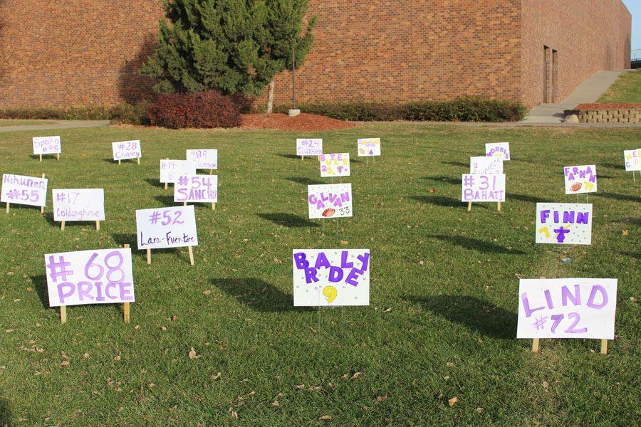 Signs dot the grass in front of Bellevue West Monday morning, wishing the football players good luck before their state final.