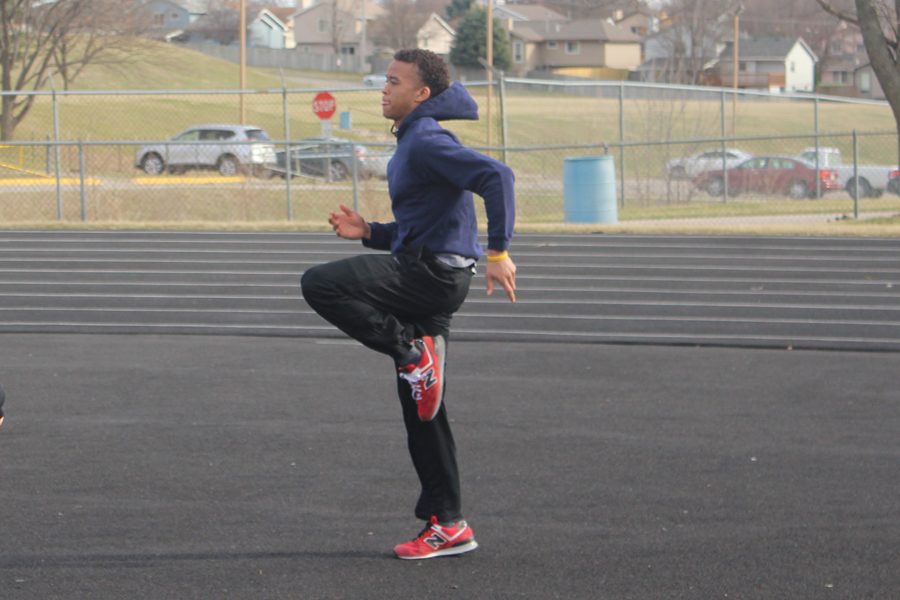 Sophomore Shane Smith participates in warm-ups during a track and field practice on March 9. Smith, who transferred to Bellevue West from Omaha North, participates in long jump, the 4x100 and the 4x400.