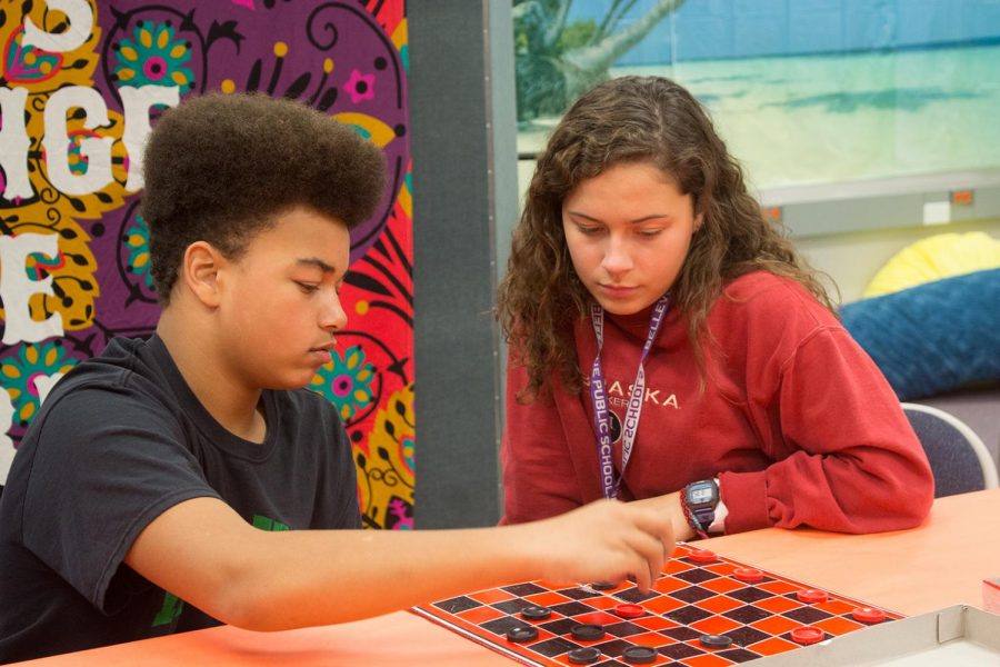 Senior Trinity Torres and eighth grader Jordan Jacobs play a friendly game of chess to get to know each other better.