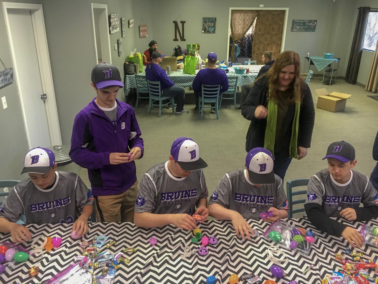 Players on the 14U Bellevue Bruins baseball team fill Easter eggs for their