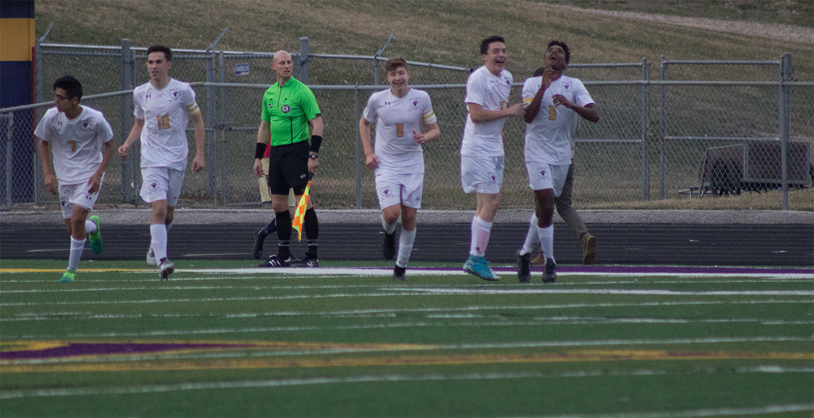 Members of the boys soccer team celebrate a goal against Elkhorn South on April 12, 2017.