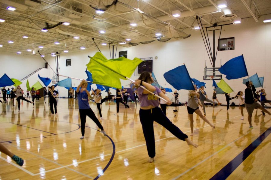 Bellevue West winter guard members spin their flags during tryouts.