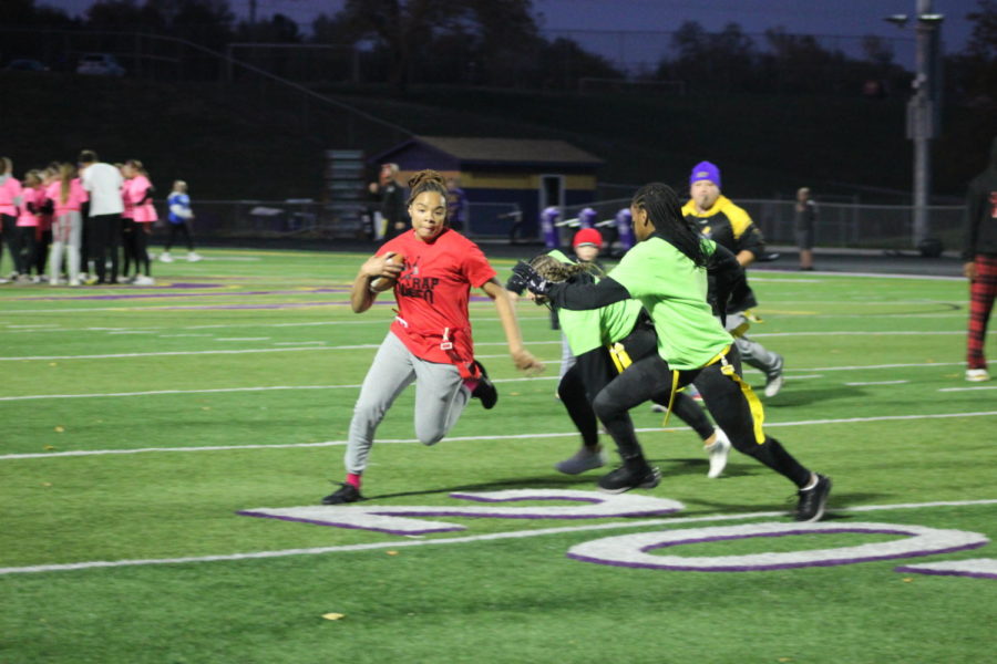 Sophomore Ahnica Russel-Brown dodges the Junior team trying to take her flag at the Powderpuff game.