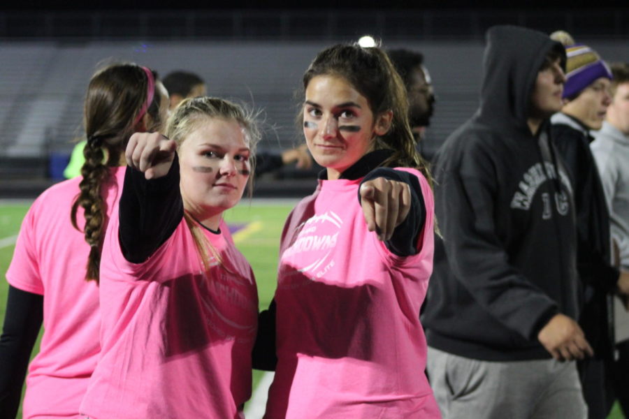 Senior’s Liv Reitsma and Grace Schaefer are pointing towards the camera at the Powderpuff game.
