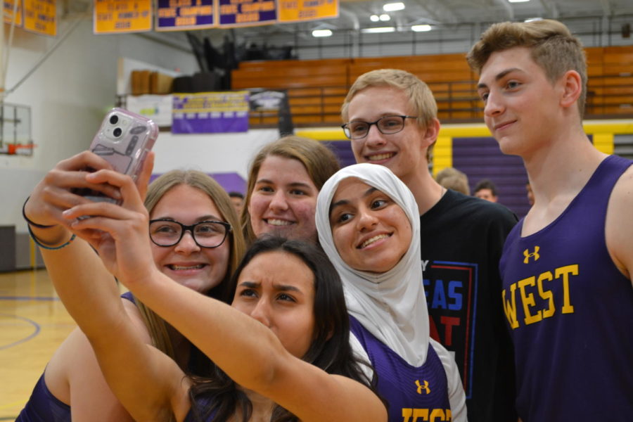 The members of the track team smile for a picture. “We’re taking pictures together as a team because we love each other,” freshman Lillian Costello said.