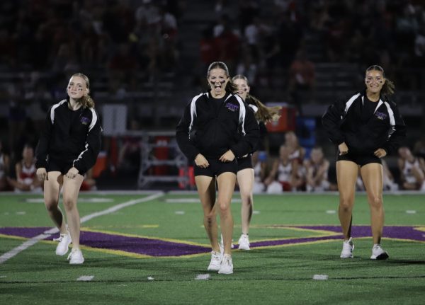 Senior Katie Crick dances with her teammates at halftime of a football game. 