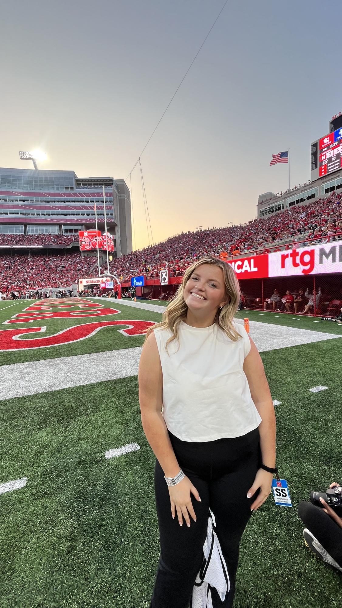 2022 alum Meg Gross stands on the field of Memorial Stadium. Photo provided by Meg Gross.