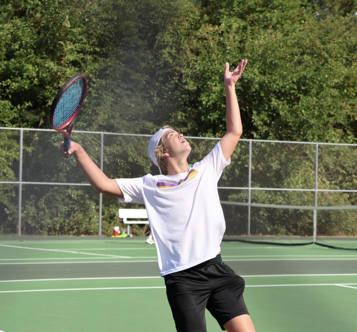  Sophomore Andrew Thomas throws the ball up to serve.