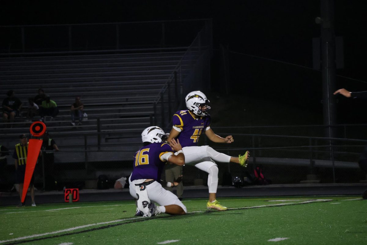 Senior Johnny Guerra kicks the ball as Junior Will Andrson lets go.
