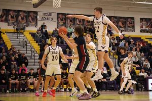 Junior Carsen Schultz jumps to block the ball.