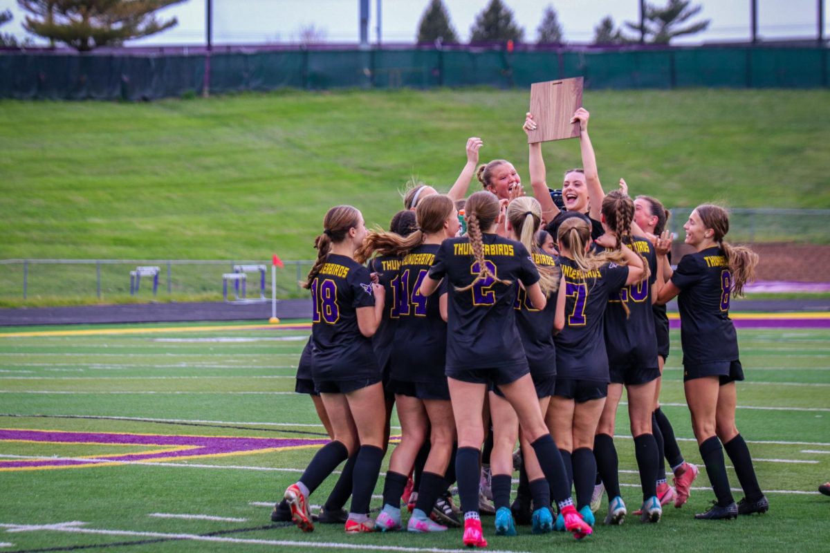 The girls soccer team celebrate as they are handed the district championship plaque.
