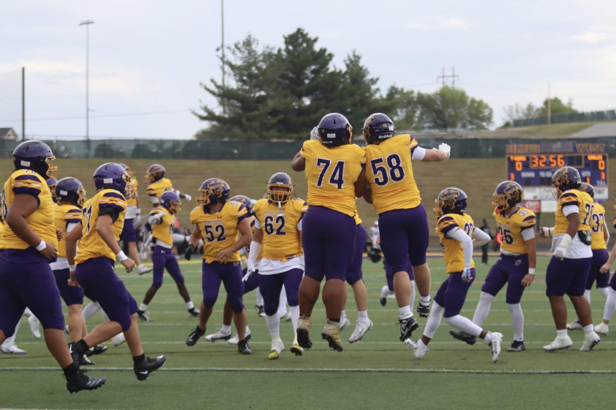 Bellevue West Football players run into a pregame  huddle.