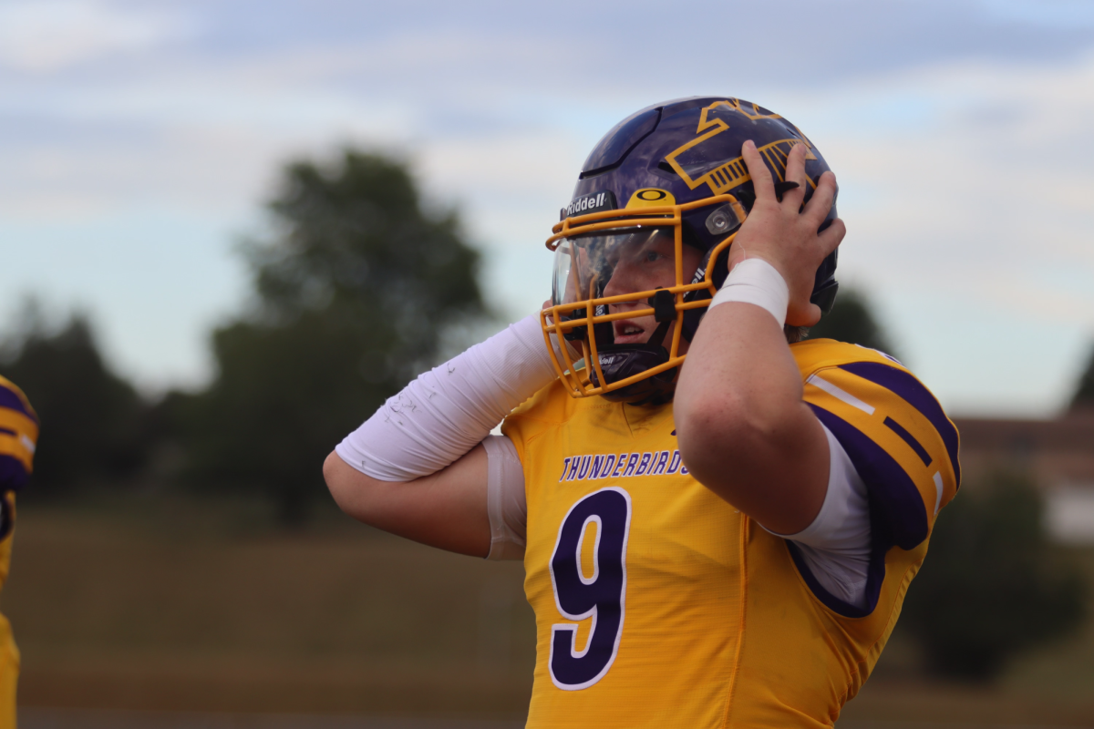Sophomore Vinnie Armstrong adjusts his helmet as he prepares to play. T.Zavala