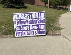 A sign advertising the mattress sale sits on the corner of the entrance to Bellevue West.
