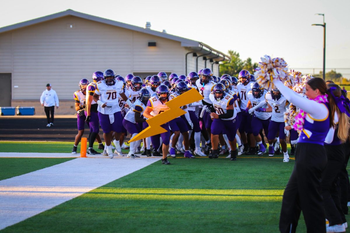 The football team rushes onto the field excited for the NSAA game of the week.